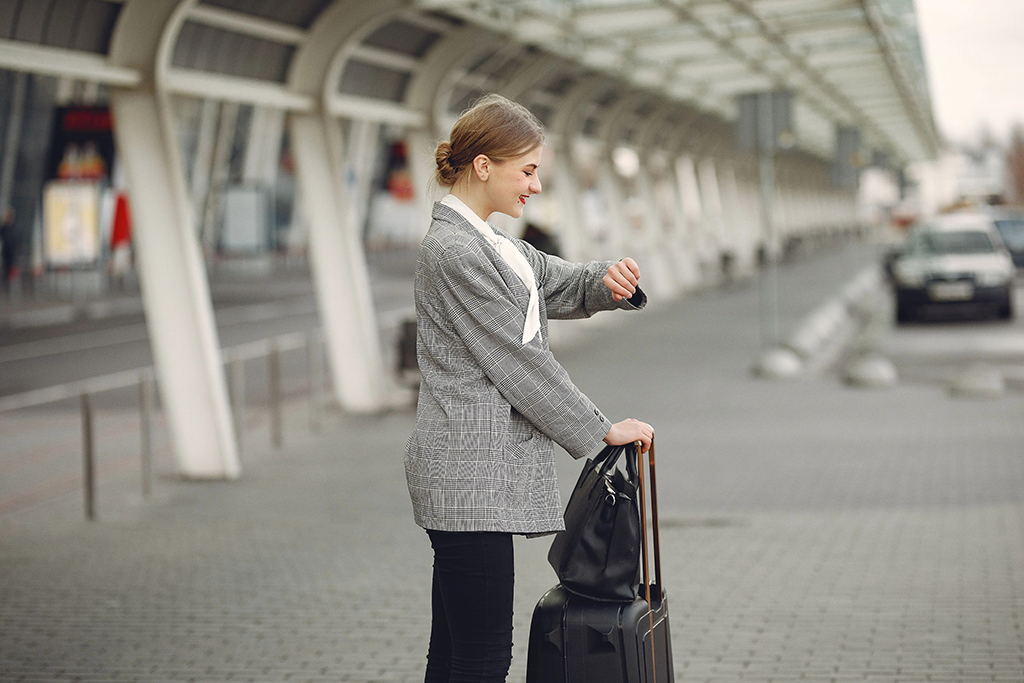 Business traveler with luggage checking her watch