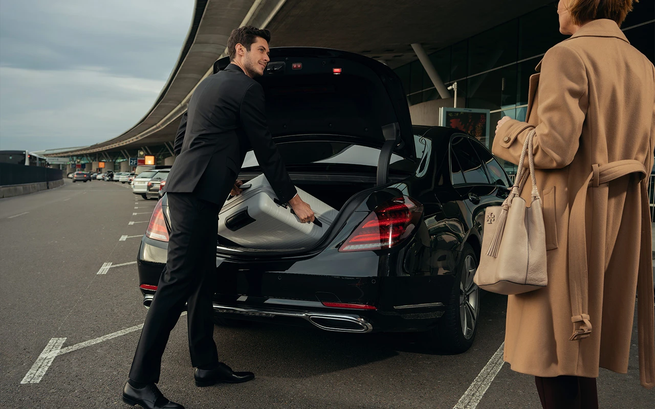Chauffeur loading luggage at an airport terminal